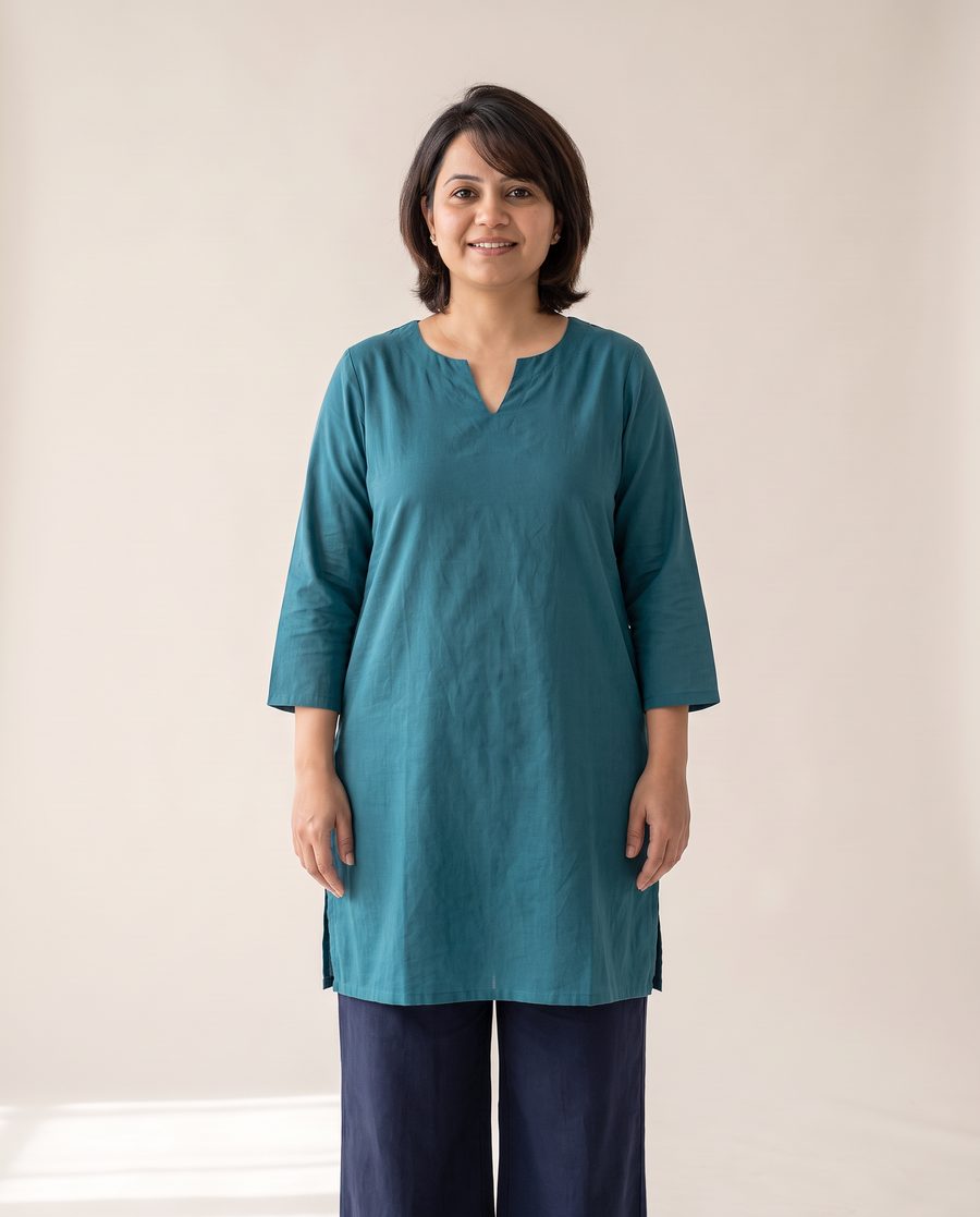 The same woman in a teal kurta with a V neckline and a chin-length layered cut