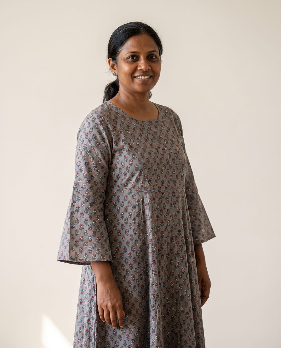 A woman in a loose grey anarkali with a busy print